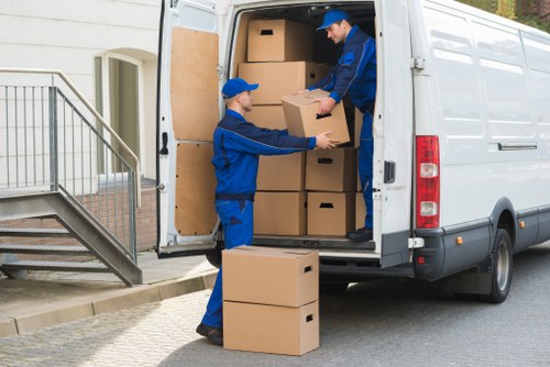 Movers carrying household items through a narrow Soho stairwell during a local relocation