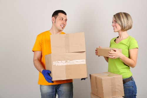Professional movers carrying items through a narrow Soho stairwell