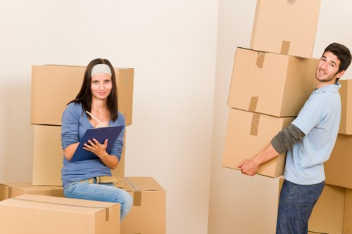 Movers transporting office desks and equipment through a central London building