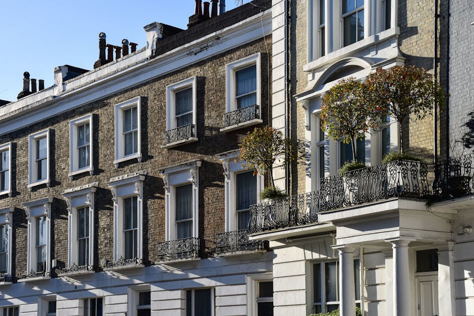 A tall, white Victorian-style building with ornate architectural details, including decorative window frames and small balconies. In the foreground, a black vintage-style streetlamp is visible, positi
